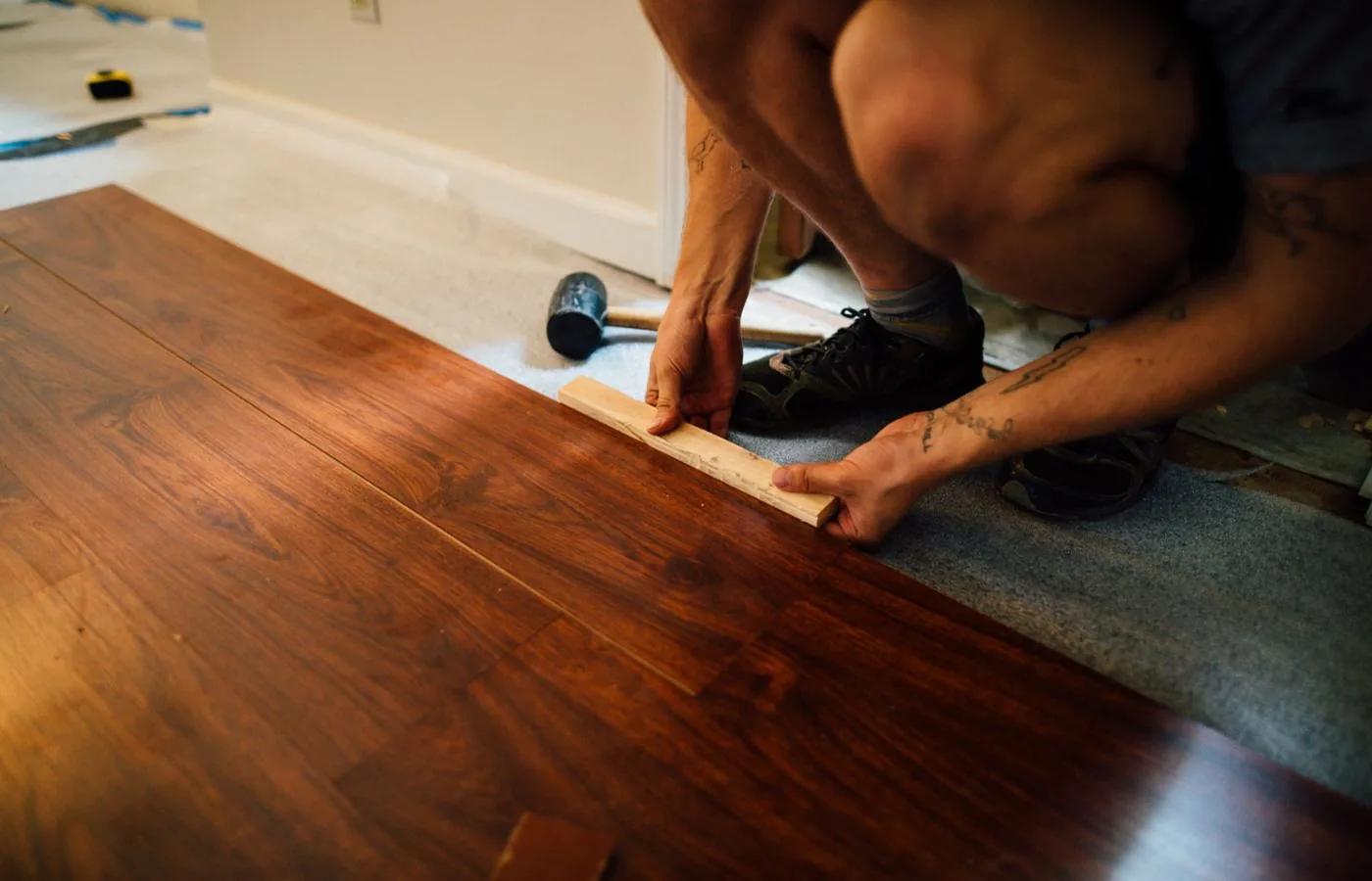 Flooring installer laying vinyl plank flooring in a home